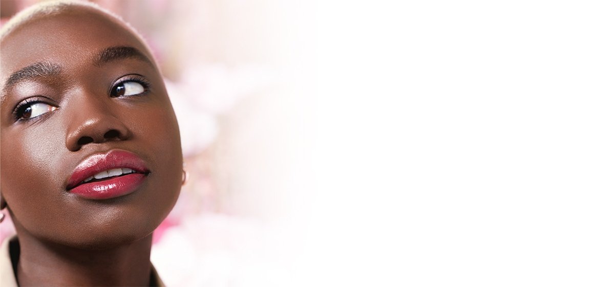 Eine junge Frau mit mit Augen-, Lippen- und Gesichts-Make-up schaut interessiert zur Seite